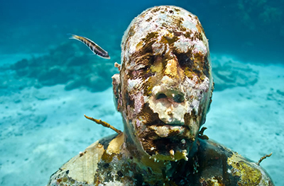 Korallal borított alakok a tenger fenekén a világ legnagyobb víz alatti kiállításán